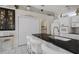 Contemporary kitchen featuring a black countertop, white cabinets and an archway leading to another room at 9400 New Orleans Dr, Weeki Wachee, FL 34613