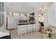 Modern kitchen with white cabinets, dark countertops, and a breakfast bar with seating, with a view into the dining area at 9400 New Orleans Dr, Weeki Wachee, FL 34613