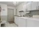 Bright laundry room features modern washer and dryer, ample cabinet space, sink and stylish chandelier at 9400 New Orleans Dr, Weeki Wachee, FL 34613