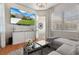 Bright living room with television showing exterior view, plush sofa, and elegant decor for a comfortable living space at 9400 New Orleans Dr, Weeki Wachee, FL 34613