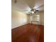 An empty bedroom shows wood flooring, neutral walls, and bright lighting from a large window at 947 Village Dr, Brooksville, FL 34601