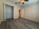 Bright bedroom with gray wood-look flooring shows a closet and view into the hallway at 947 Village Dr, Brooksville, FL 34601