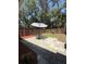 Back yard patio with a table, chairs and an umbrella, surrounded by a wooden fence at 947 Village Dr, Brooksville, FL 34601