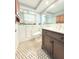 Bathroom featuring a walk-in shower, modern fixtures, vanity, and patterned tile flooring at 9850 Richwood Ln, Port Richey, FL 34668