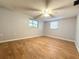 Cozy bedroom with wood flooring, two windows, and a ceiling fan at 9850 Richwood Ln, Port Richey, FL 34668