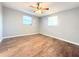Bright bedroom with laminate wood flooring, two windows, and a ceiling fan at 9850 Richwood Ln, Port Richey, FL 34668
