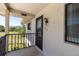 Balcony view featuring a 'Welcome' sign, railing, exterior home details, and pleasant green space view at 9970 Eagles Point Cir # 3, Port Richey, FL 34668