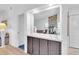 Hallway featuring built-in cabinets and a large mirror reflecting the living room, creating depth and light at 9970 Eagles Point Cir # 3, Port Richey, FL 34668