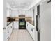 Bright kitchen features white cabinets, tiled floor and black appliances, providing a modern cooking space at 9970 Eagles Point Cir # 3, Port Richey, FL 34668