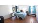 Inviting bedroom with wood-look floors, large window, and blue accents, creating a calming retreat at 10309 Honeysuckle Ln, Port Richey, FL 34668