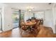 Bright dining space with a round wood table, mirrored accent wall, and easy access to the outdoors at 10309 Honeysuckle Ln, Port Richey, FL 34668