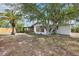 Cozy home featuring mature trees and landscaping, adding to its curb appeal at 10309 Honeysuckle Ln, Port Richey, FL 34668