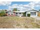 Inviting single-Gathering home with an attached garage, complemented by a neatly kept yard and clear blue skies at 10309 Honeysuckle Ln, Port Richey, FL 34668