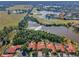 Panoramic aerial shot of a residential area showcasing tile-roofed homes next to a golf course and lake at 1033 Tuscany Dr, Trinity, FL 34655