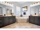 Well-lit bathroom with double vanities, a soaking tub, and a large picture window at 1033 Tuscany Dr, Trinity, FL 34655