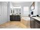 A bathroom with a soaking tub, a double sink vanity with a large mirror, and a window at 1033 Tuscany Dr, Trinity, FL 34655