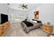 Spacious bedroom with soft carpet, neutral walls, a ceiling fan, and a sitting area by the windows at 1033 Tuscany Dr, Trinity, FL 34655