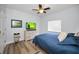 A bedroom with a ceiling fan, a TV on a white dresser, and a blue bedspread at 1033 Tuscany Dr, Trinity, FL 34655