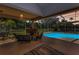 Outdoor covered patio with fireplace and furniture overlooking the pool and expansive yard at 1033 Tuscany Dr, Trinity, FL 34655