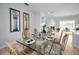 Light-filled dining room with large glass table, seating for six, and modern artwork at 1033 Tuscany Dr, Trinity, FL 34655