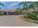 Charming home with a three car garage, brick paved driveway, and lush tropical landscaping at 1033 Tuscany Dr, Trinity, FL 34655