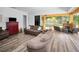 Expansive living area flows into an outdoor lanai with a stone fireplace, pool view, and lush backyard at 1033 Tuscany Dr, Trinity, FL 34655