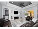 Spacious living room featuring a tray ceiling, a built-in entertainment center, and sliding doors to the pool area at 1033 Tuscany Dr, Trinity, FL 34655