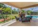 Outdoor living with a stone fireplace, wicker furniture, and access to the sparkling pool at 1033 Tuscany Dr, Trinity, FL 34655