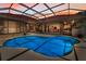 Beautiful backyard pool featuring an outdoor enclosure and seamless flow to the home's interior at 1033 Tuscany Dr, Trinity, FL 34655