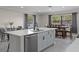Kitchen island view into a dining area with seating and natural light from the windows at 11137 Addison St, Spring Hill, FL 34609