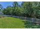 Large, grassy backyard enclosed by a white fence provides a secure and private outdoor area at 12800 Solola Way, Trinity, FL 34655