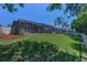 Spacious backyard featuring lush green grass and a screened-in enclosure, ideal for outdoor living at 12800 Solola Way, Trinity, FL 34655