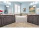 Elegant bathroom featuring dual vanities, a standalone tub, and neutral tiling at 12800 Solola Way, Trinity, FL 34655