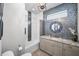 Modern bathroom featuring stylish vanity with granite countertop and a decorative accent wall with mosaic tiles at 12800 Solola Way, Trinity, FL 34655