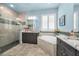 Bright bathroom with a soaking tub, a glass-enclosed shower, and dual vanity sinks at 12800 Solola Way, Trinity, FL 34655