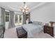 Bright bedroom featuring a tray ceiling, large windows, French doors, and a neutral color palette at 12800 Solola Way, Trinity, FL 34655