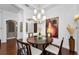 Inviting dining room with a stylish chandelier, hardwood floors, artwork, and seamless flow to the adjacent rooms at 12800 Solola Way, Trinity, FL 34655