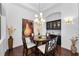 Elegant dining room with stylish chandelier, hardwood floors, built-in cabinetry, and an adjacent artwork display at 12800 Solola Way, Trinity, FL 34655