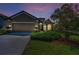 Home exterior at twilight with lush landscaping, manicured lawn, and warm lighting creating a welcoming atmosphere at 12800 Solola Way, Trinity, FL 34655