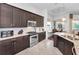 This kitchen features stainless steel appliances, granite countertops, and dark wood cabinets at 12800 Solola Way, Trinity, FL 34655