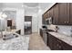 Kitchen features stainless appliances, dark cabinetry, tiled backsplash, and granite countertops at 12800 Solola Way, Trinity, FL 34655