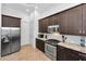 Modern kitchen features stainless appliances, dark cabinetry, granite countertops, and tile backsplash at 12800 Solola Way, Trinity, FL 34655