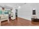 Living room features hardwood floors, modern white wall paneling, and access to the pool through sliding glass doors at 12800 Solola Way, Trinity, FL 34655