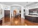 Open-concept living area featuring hardwood floors, modern lighting, and entry to the kitchen and dining room at 12800 Solola Way, Trinity, FL 34655