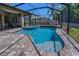 Inviting screened-in pool with a waterfall feature, spa and paver deck, perfect for outdoor enjoyment at 12800 Solola Way, Trinity, FL 34655