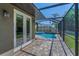 A covered patio overlooks a screened-in pool with spa, perfect for relaxing and entertaining outdoors at 12800 Solola Way, Trinity, FL 34655