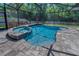 Relaxing screened-in pool area with a spa and waterfall feature, surrounded by a brick patio and lush greenery at 12800 Solola Way, Trinity, FL 34655