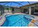 Beautiful screened-in pool with attached spa and brick paver deck offers a relaxing outdoor oasis at 12800 Solola Way, Trinity, FL 34655