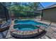 Sparkling pool and spa surrounded by a paved deck and a screened enclosure at 12800 Solola Way, Trinity, FL 34655