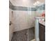 Modern shower with river rock base, neutral tiles, and mosaic accents at 12800 Solola Way, Trinity, FL 34655